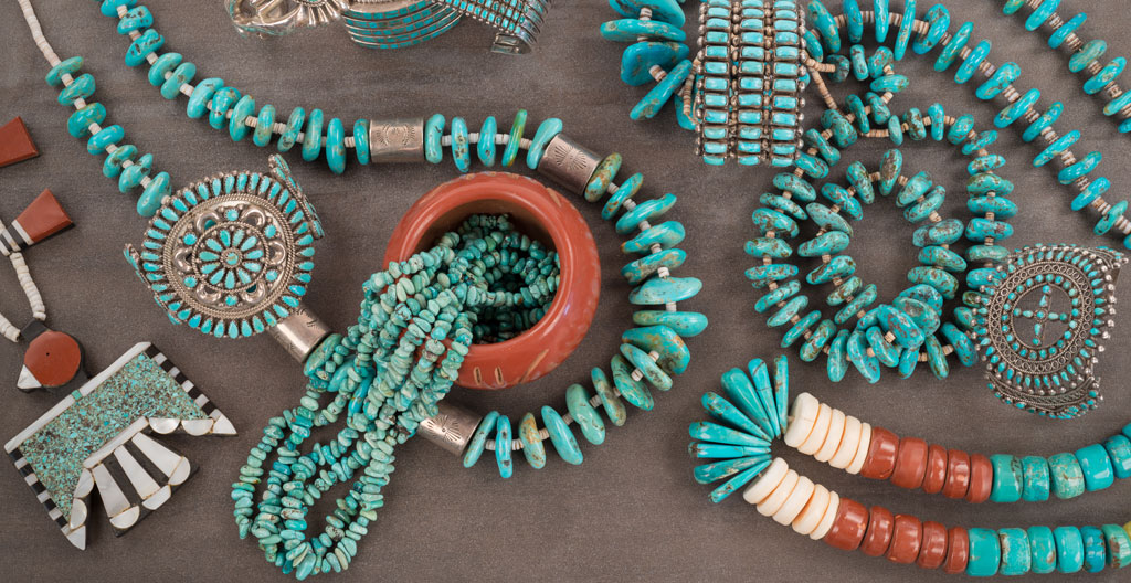 Pied à coulisse métallique posé à côté de perles heishi blanches et beiges sur un établi en bois clair d'atelier