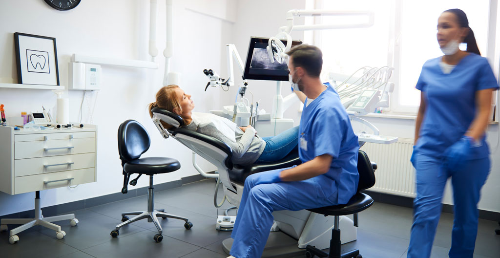 Une personne seule dans la salle d'attente d'un cabinet orthodontique, consultant un document d'information avec expression de soulagement
